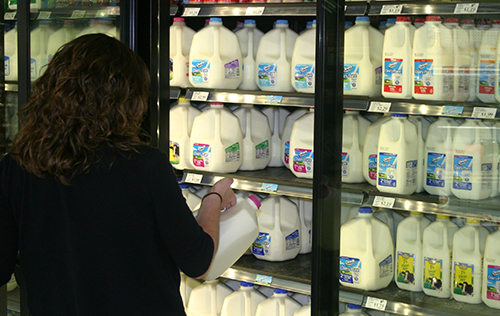 consumer looking at expiration date on milk