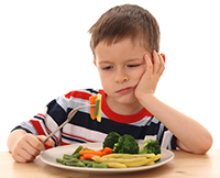 boy thinking about eating his vegetables
